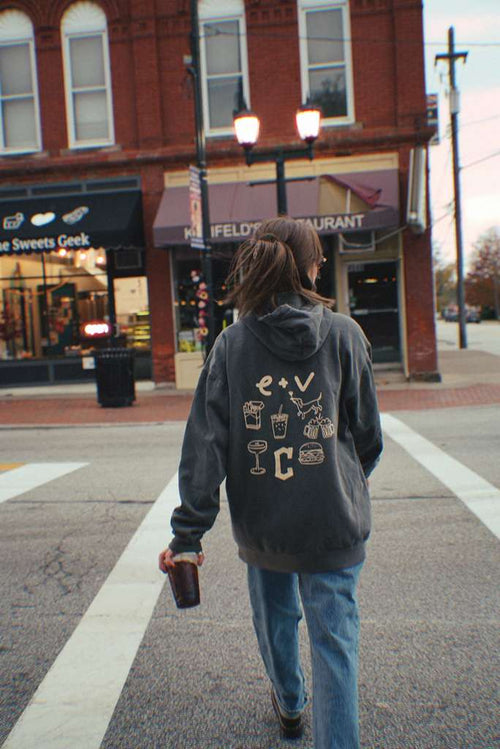 Back of Erie + Vine hoodie featuring playful graphics of food, drinks, and a dog—capturing the downtown Willoughby bar's cozy, nostalgic streetwear vibe.
